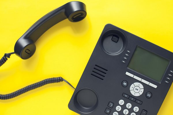 8X8 extension dialing voip service black voip phone on yellow background